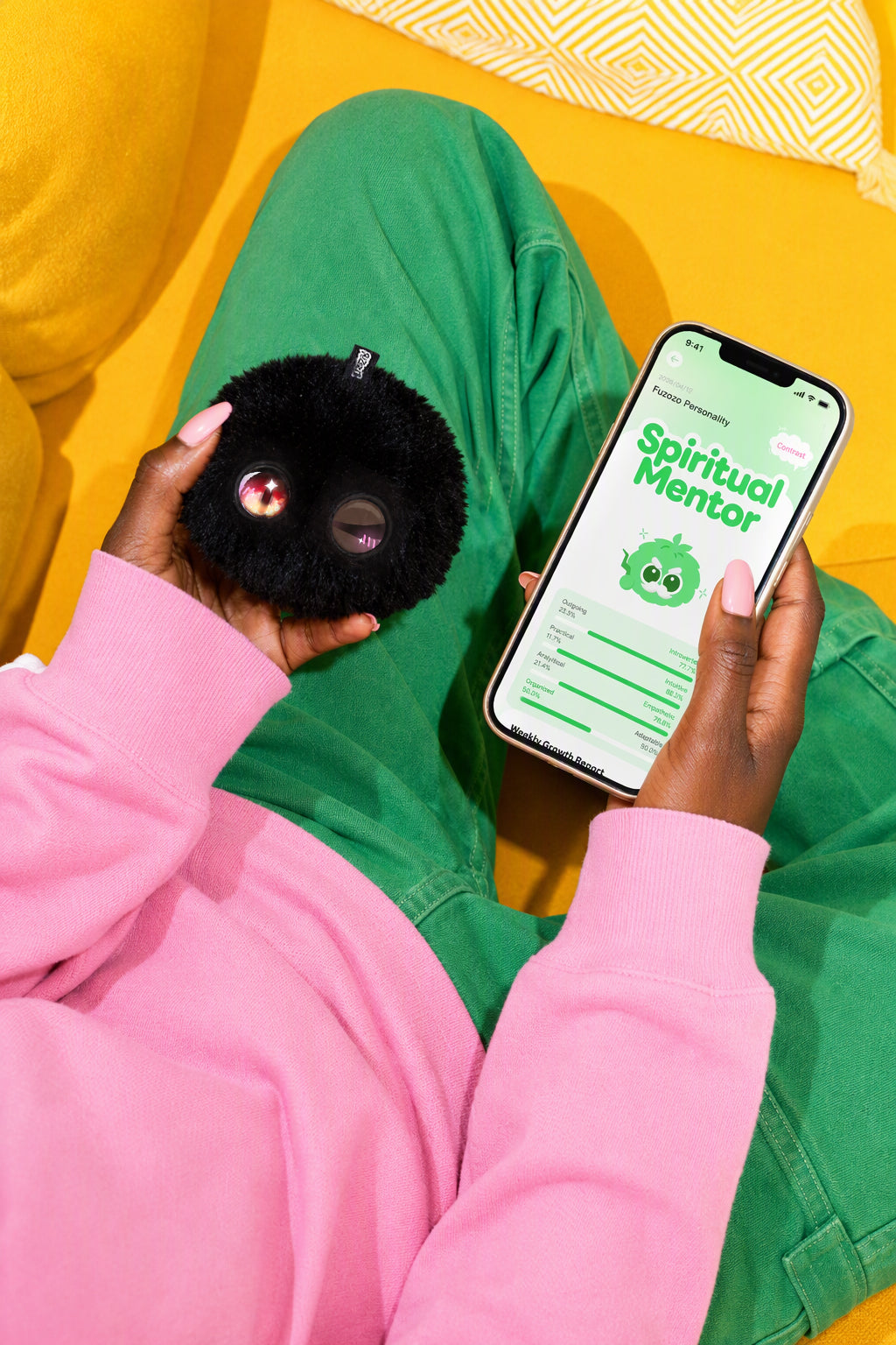A black Fuzozo beside its personality screen in the app